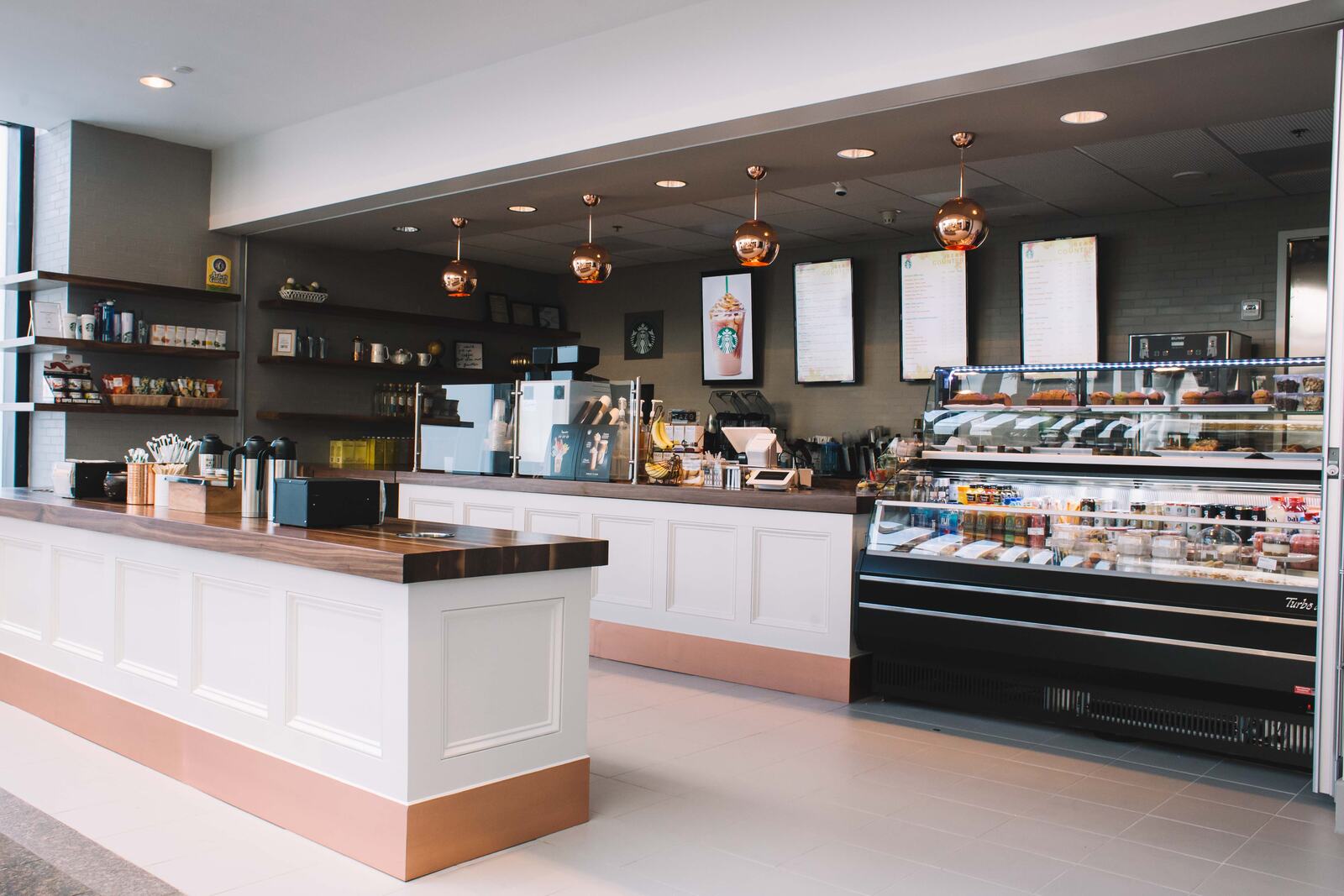 The Bean Counter café counter at 500 Northpark, with copper pendant lights and a full pastry case